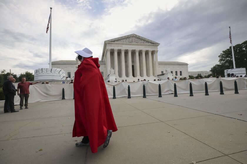 WASHINGTON, DC - OCTOBER 04: A Pro-choice activist dressed in a Handmaid costume as they demonstrate outside the Supreme Court on October 04, 2021 in Washington, DC. The Supreme Court's new term, which started today is expected to take up contentious issues including an abortion rights case that is a direct challenge to Roe v. Wade. (Photo by Kevin Dietsch/Getty Images)