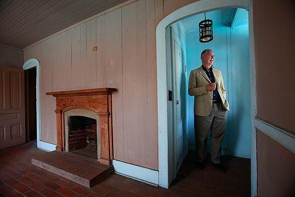 Gene Dryden of the San Marino Historical Society surveys the interior of the Michael White Adobe, a historical structure dating from 1845 on the campus of the city's high school.