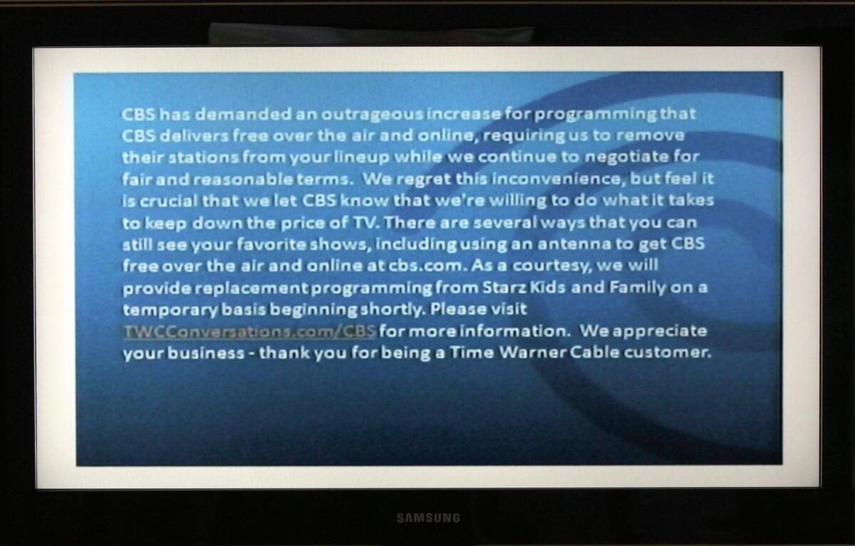 A television screen shows the CBS channel with an announcement by Time Warner Cable in Los Angeles.