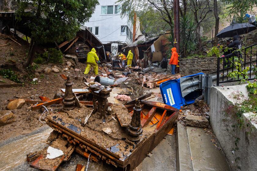 A grand piano lies upside down in the middle of Caribou Lane near a Beverly Crest home that was pushed off its foundation.