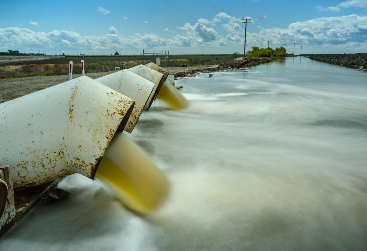 Water pours through a Fresno Slough Water District lift near Tranquillity, Calif., where the irrigation district shored up levees in preparation for large amounts of snowmelt. (Tomas Ovalle / For The Times)