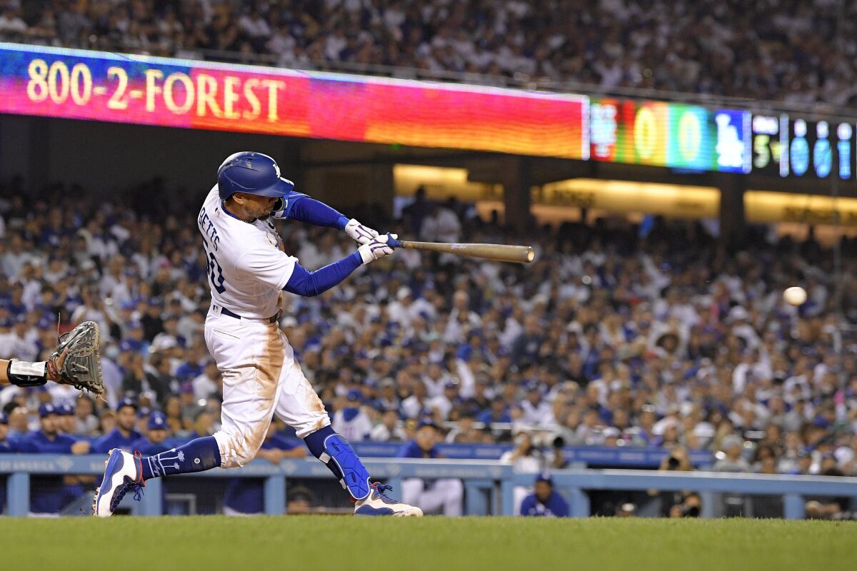 Los Angeles Dodgers' Mookie Betts hits an RBI single during the fifth inning of a baseball game against the New York Mets on Thursday, June 2, 2022, in Los Angeles. (AP Photo/Mark J. Terrill)