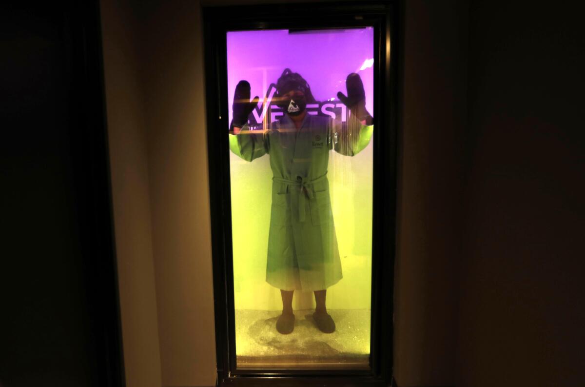 A man, wearing spa wrap socks, slippers and protective robe, undergoes Cryotherapy