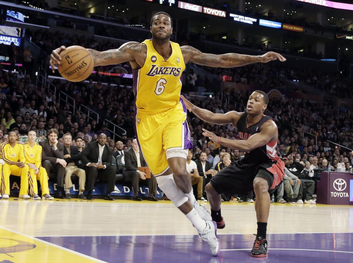 Then-Lakers forward Earl Clark saves the ball as Toronto Raptors' Kyle Lowry defends during a game in Los Angeles in March. A California gambling commissioner says the state could reap hundreds of millions of dollars annually if betting on sports were legalized.