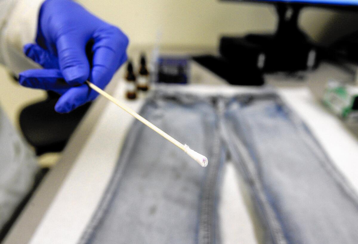 Forensic DNA Supervisor Lisa Brewer holds a cotton swab that she tested for blood evidence on blue jeans at the opening of the Verdugo Regional Crime Laboratory in the Glendale Police Department on Thursday, April 12, 2012.