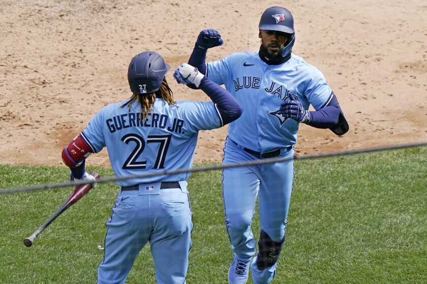 Toronto Blue Jays Vladimir Guerrero Jr. (27) celebrates with Blue Jays Teoscar Hernandez after Hernandez hit a game-tying solo home run off New York Yankees starting pitcher Gerrit Cole during the sixth inning of a major league baseball game on opening day at Yankee Stadium, Thursday, April 1, 2021, in New York. (AP Photo/Kathy Willens)