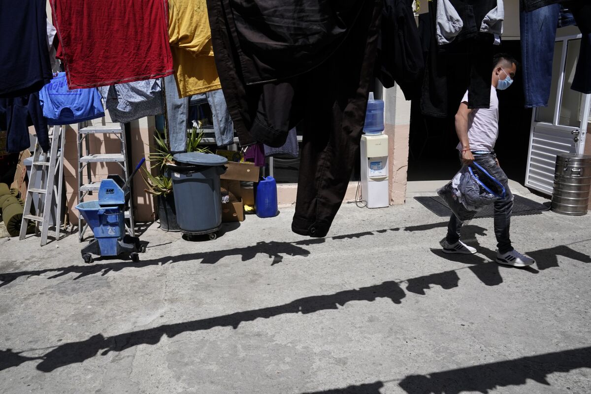 ARCHIVO - Juan, de Colombia, tiende su ropa para que se seque en un albergue para migrantes