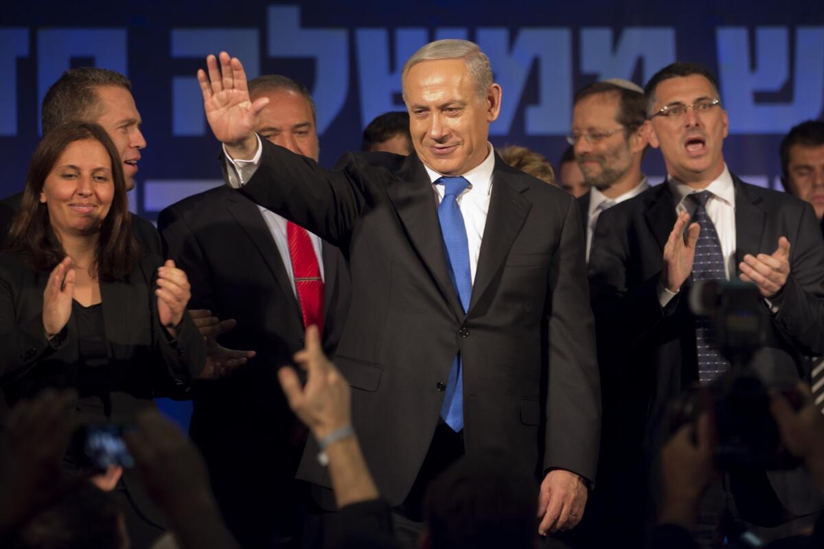 Israeli Prime Minister and chairman of the Likud party Benjamin Netanyahu, center, waves to supporters in the Tel Aviv party headquarters early Wednesday after his Likud-Beiteinu list came out on top in the Israeli general election.