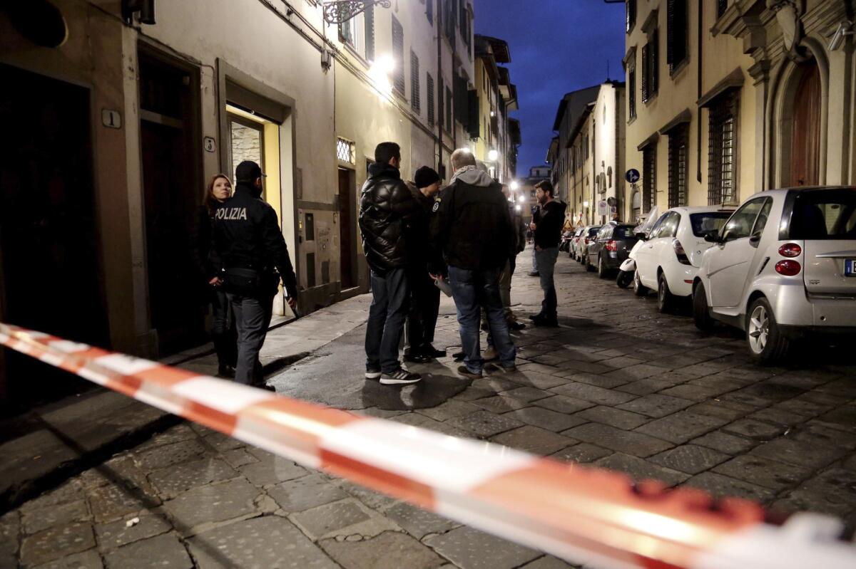 Italian police officers stand outside an apartment where Ashley Oslen, an American woman, was found dead in Florence on Saturday.