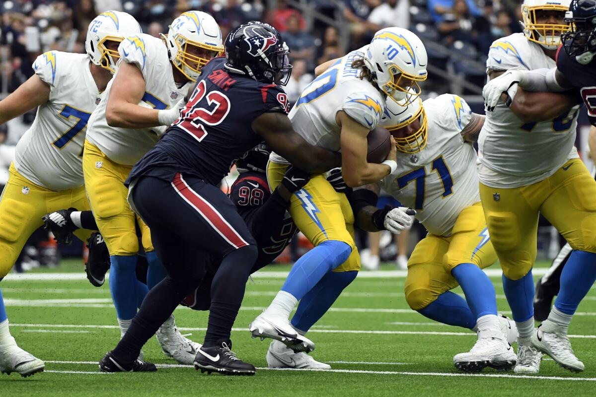 Chargers quarterback Justin Herbert is sacked by Houston Texans defensive lineman Chris Smith and Michael Dwumfour.