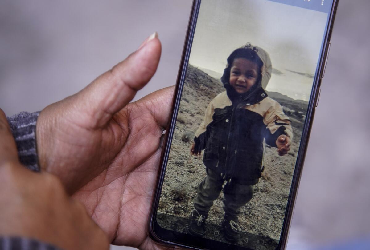 Ana sostiene el celular con las fotos de su hijo Carlitos 