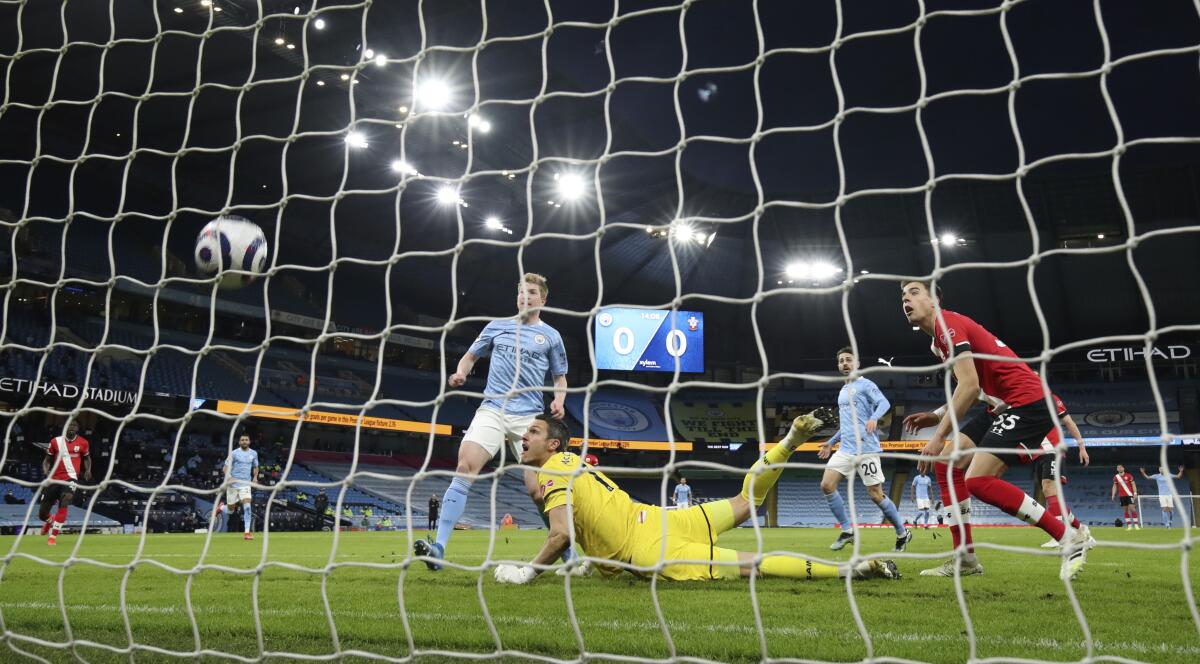 Manchester City's Kevin De Bruyne, left, scores his side's opening goal during the English Premier League soccer match between Manchester City and Southampton at the Etihad Stadium in Manchester, England, Wednesday, March 10, 2021. (Clive Brunskill/Pool via AP)