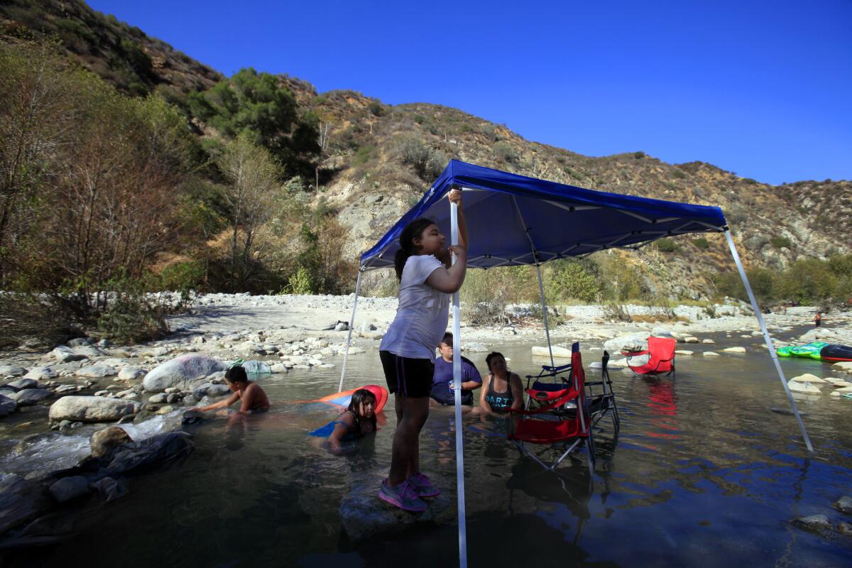 Precious Adams, 8, center, of Norwalk plays in the water of the East Fork of the San Gabriel Valley River in the Angeles National Forest Saturday, August 23, 2014. President Obama proclaimed the San Gabriel Mountains a National Monument last October.