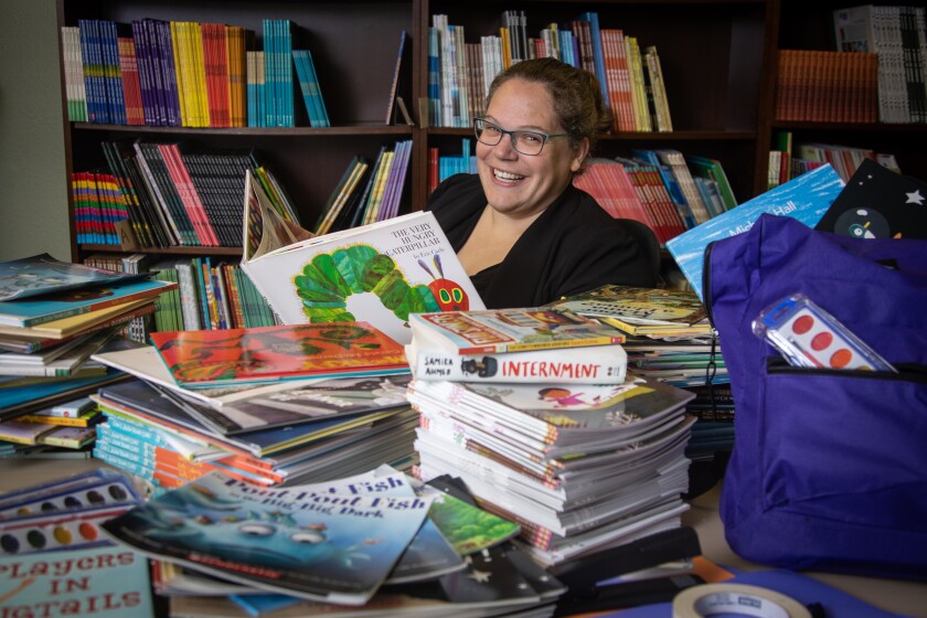 Words Alive executive director Rachael Orose is shown with books and learning kits to be distributed to local families.