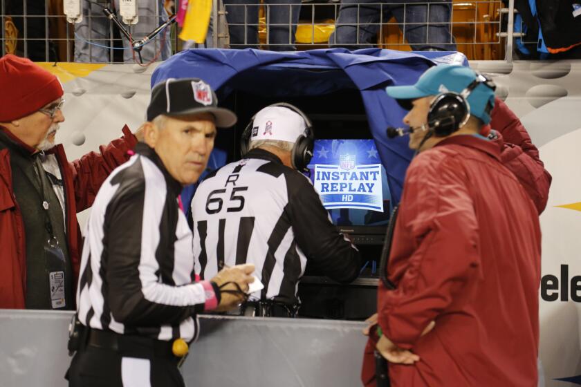 NFL referee Walt Coleman, center, enters the Instant Replay sideline booth to review a play during a game between the Pittsburgh Steelers and Houston Texans on Oct. 20.