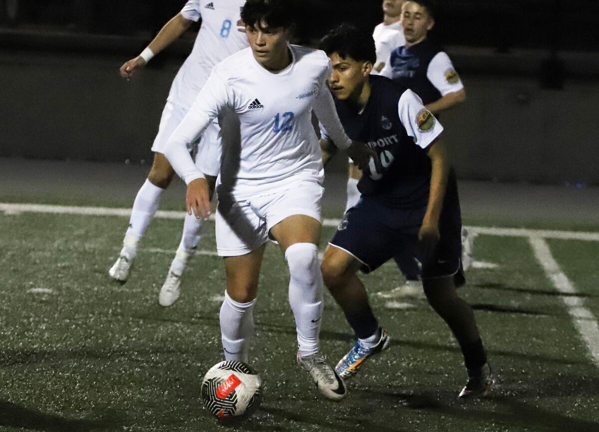 Corona del Mar's Bryce Roberts (12) dribbles the ball against Newport Harbor in the Battle of the Bay on Wednesday.