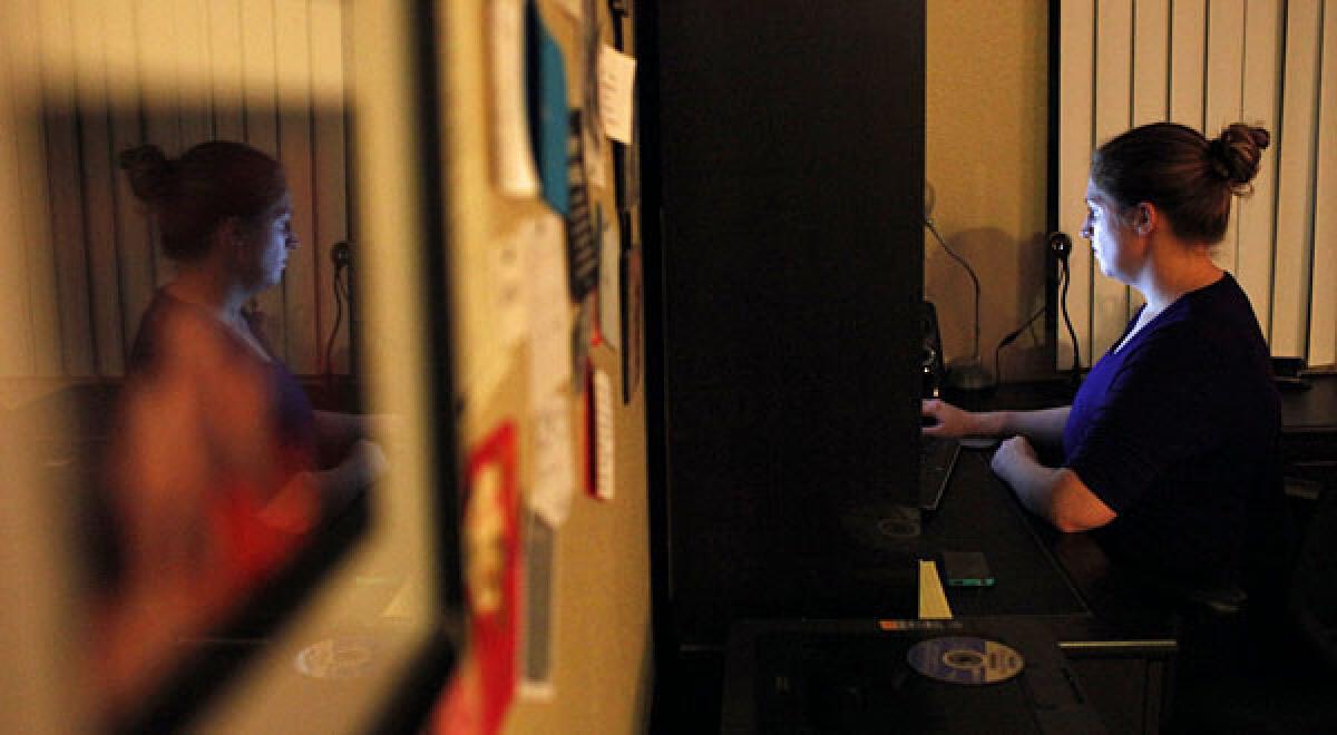 Jennifer Clay, a student in Western Governors University, an online school, takes a business course test online, under the view of a video camera, at her apartment in Los Angeles.