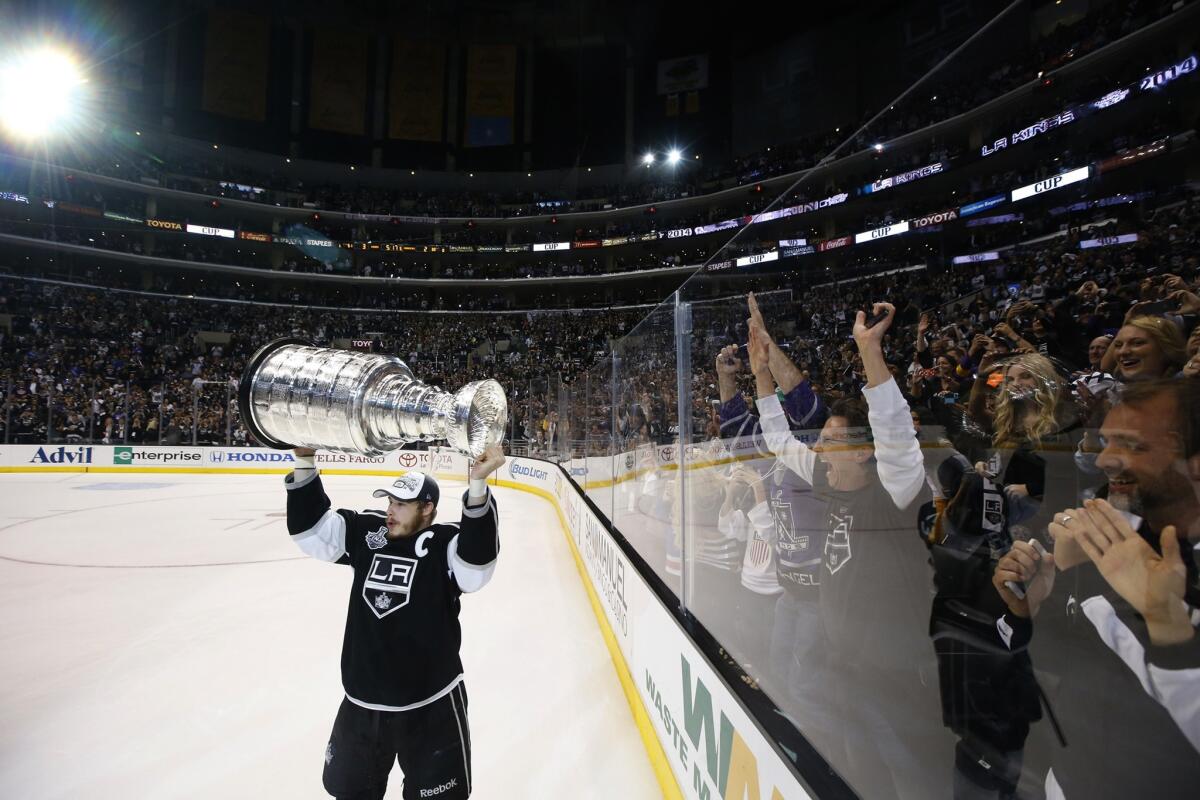 Dustin Brown raises the Stanley Cup for thousands of Kings fans following L.A.'s 3-2, double-overtime win Friday over the New York Rangers at Staples Center.