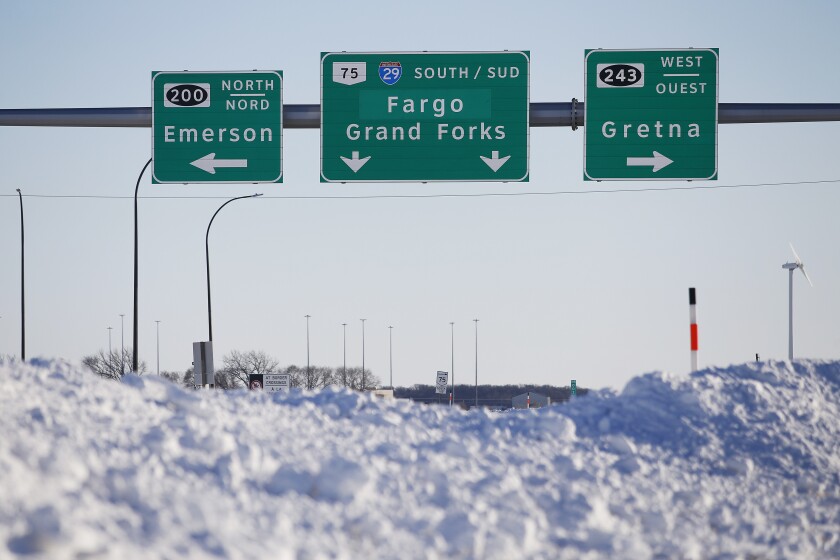 Road signage is posted just outside of Emerson, Manitoba on Thursday, Jan. 20, 2022. A Florida man was charged Thursday with human smuggling after the bodies of four people, including a baby and a teen, were found in Canada near the U.S. border, in what authorities believe was a failed crossing attempt during a freezing blizzard. The bodies were found Wednesday in the province of Manitoba just meters (yards) from the U.S. border near the community of Emerson. (John Woods/The Canadian Press via AP)