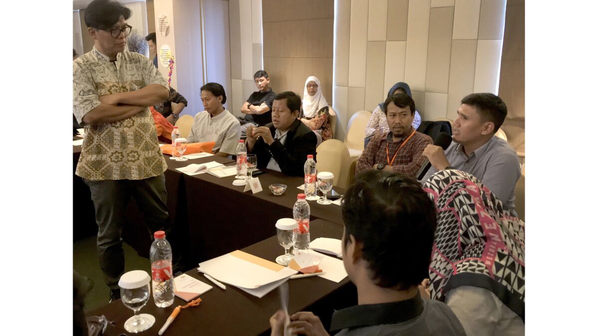Noor Huda Ismail, left, leads a conference at a hotel in Jakarta. The "formers" are in the front row.