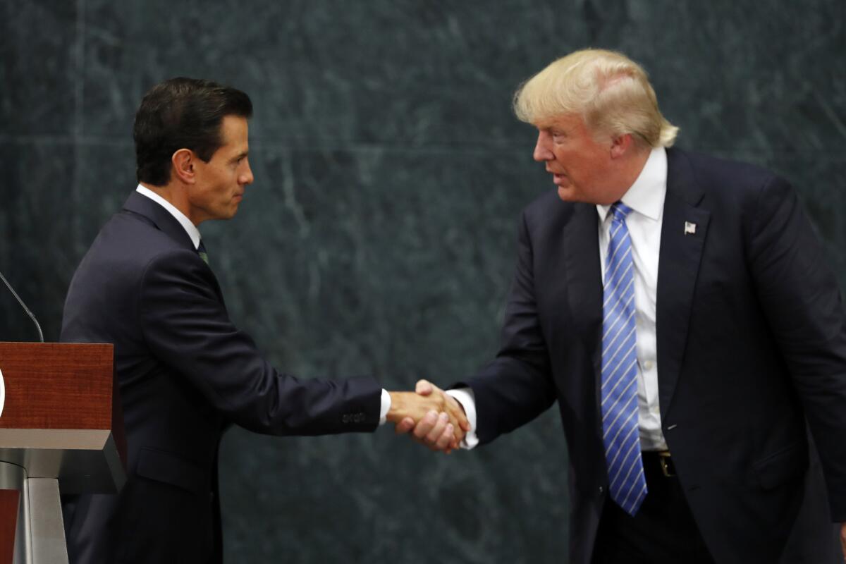 Mexico President Enrique Pena Nieto, left, and Republican presidential nominee Donald Trump shake hands after a joint statement in Mexico City.