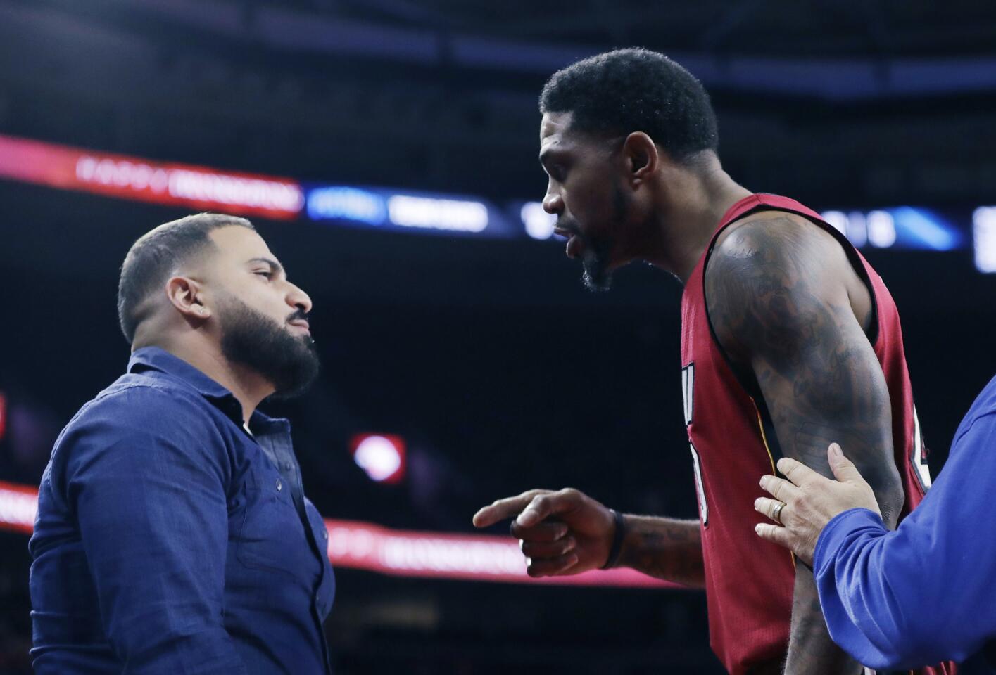 Miami Heat forward Udonis Haslem is separated from a fan who Haslem felt was taunting him during the second half of an NBA basketball game against the Detroit Pistons, Wednesday, Nov. 23, 2016 in Auburn Hills, Mich. (AP Photo/Carlos Osorio)