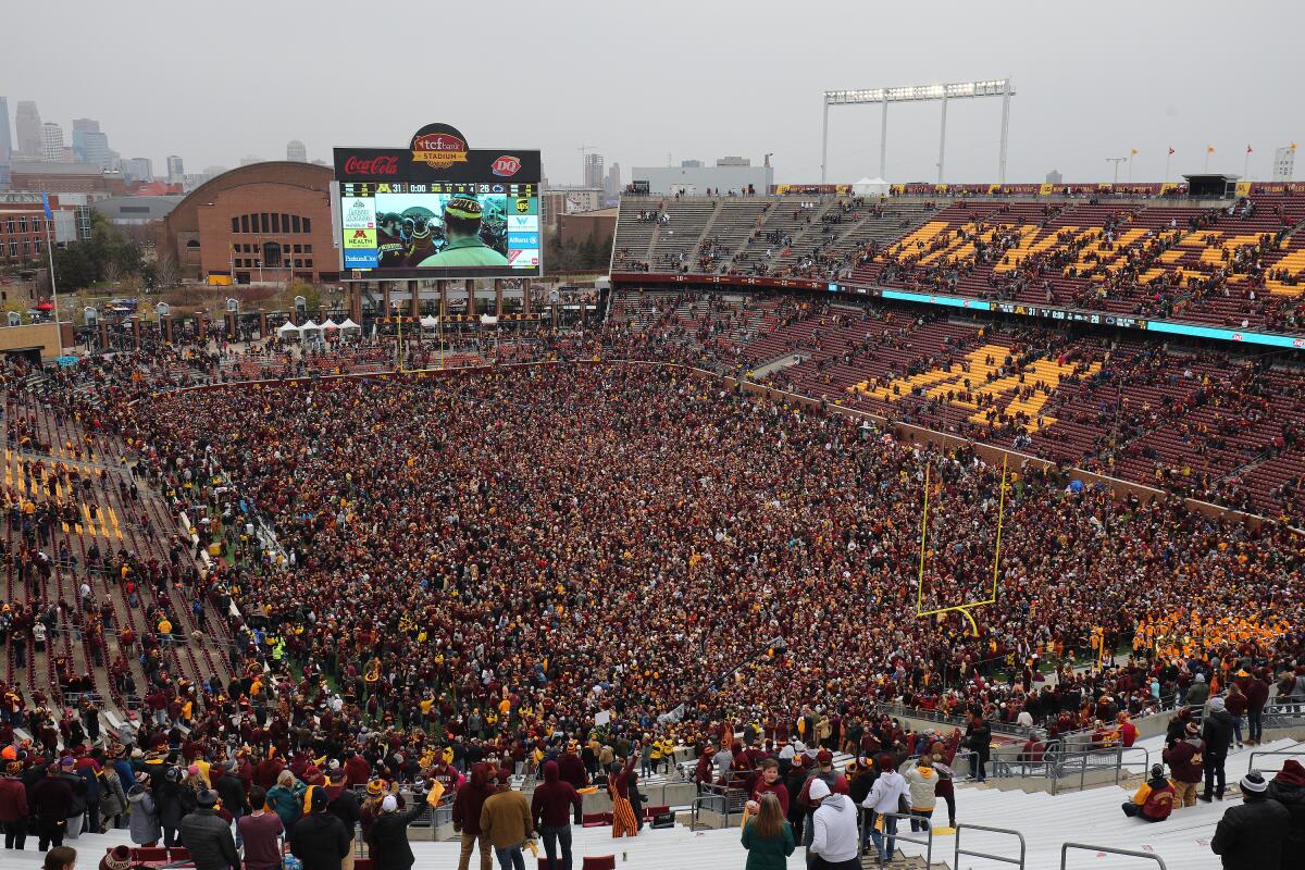 Minnesota fans storm the field after the Gophers beat Penn State