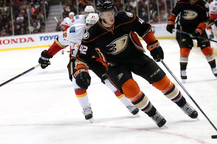 Ducks defenseman Josh Manson wins a race to the puck with Calgary center Paul Byron during a game Tuesday at Honda Center.
