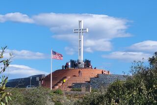 The Mount Soledad National Veterans Memorial stands out against a bright sky.