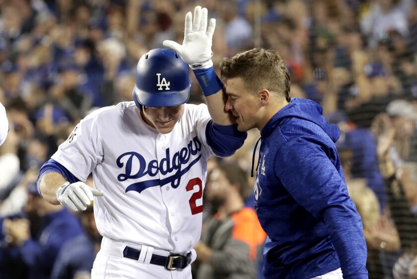 Chase Utley is congratulated by Enrique Hernandez after scoring a run in Game Six of the 2017 World Series at Dodger Stadium.