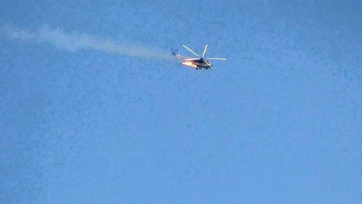 A burning Syrian combat helicopter goes down over Damascus in an image from video on YouTube.