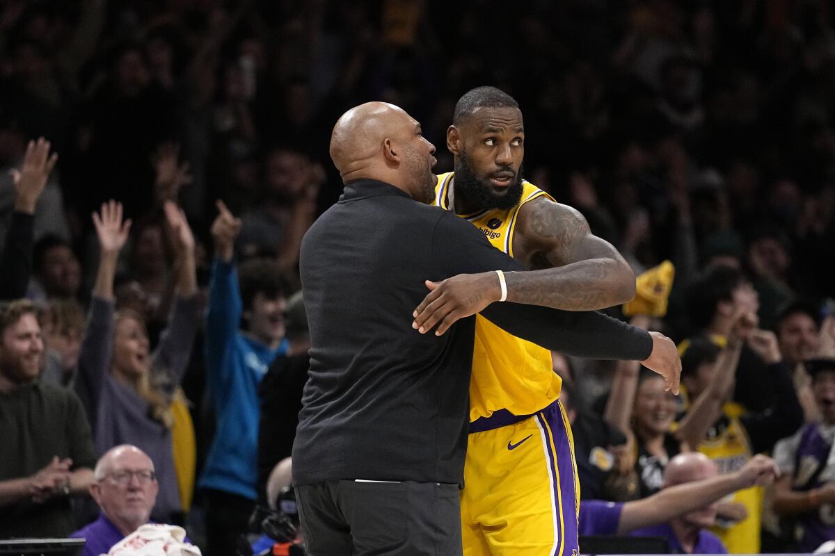 Lakers head coach Darvin Ham, left, hugs forward LeBron James after an overtime win last week.