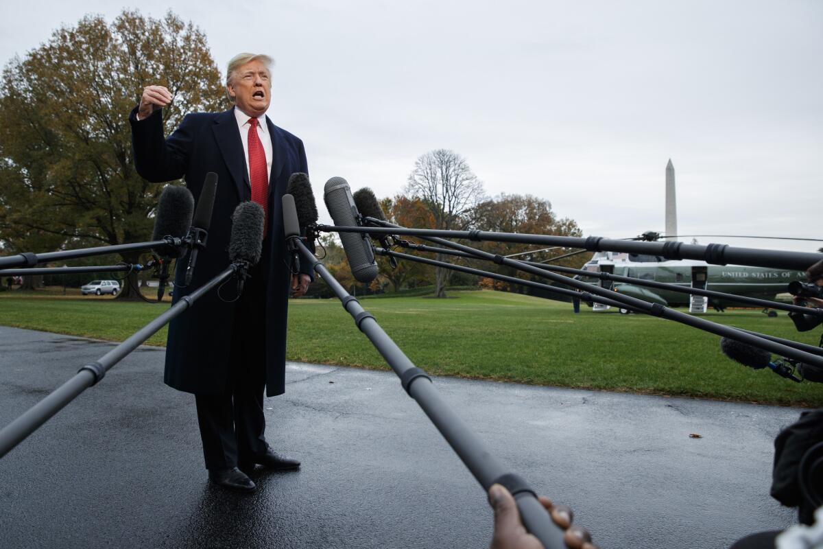 President Trump talks with reporters before departing for France on the South Lawn of the White House on Nov. 9.