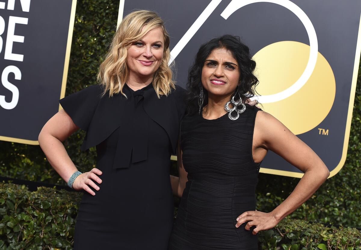 Amy Poehler, left, and Saru Jayaraman arrive at the 75th Golden Globes.