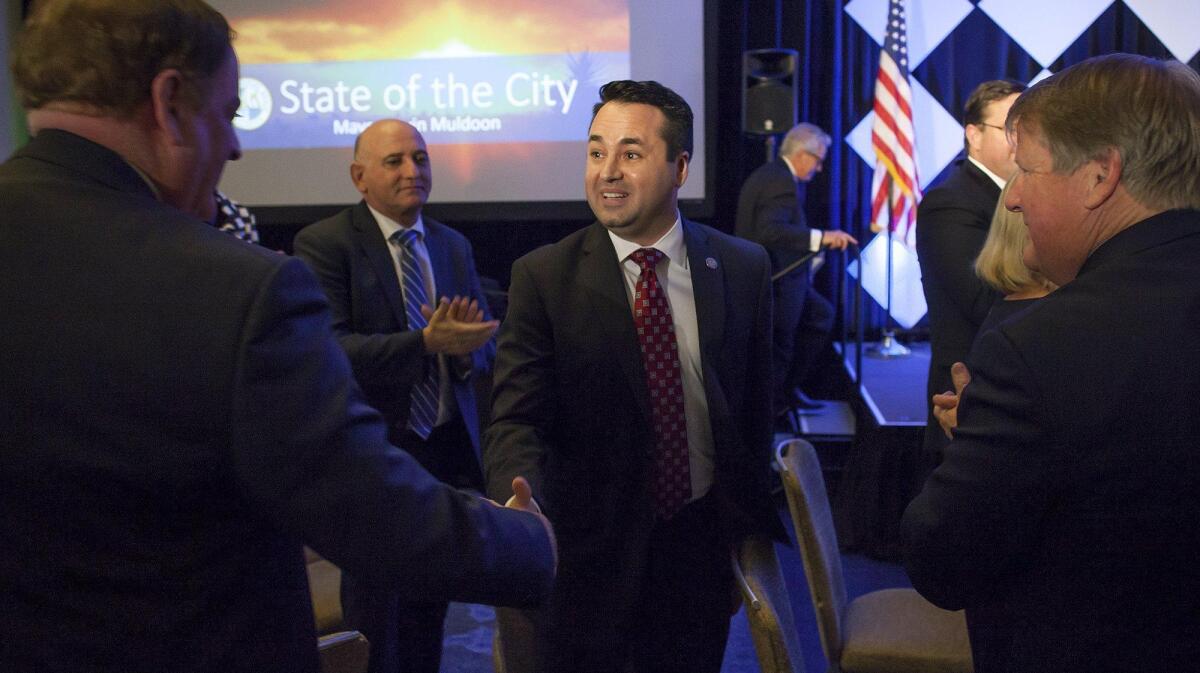 Newport Beach Mayor Kevin Muldoon, center, shakes hands with former Mayor Keith Curry after giving the state of the city address during the 36th annual Mayor’s Dinner at the Newport Beach Marriott Hotel and Spa on Friday.