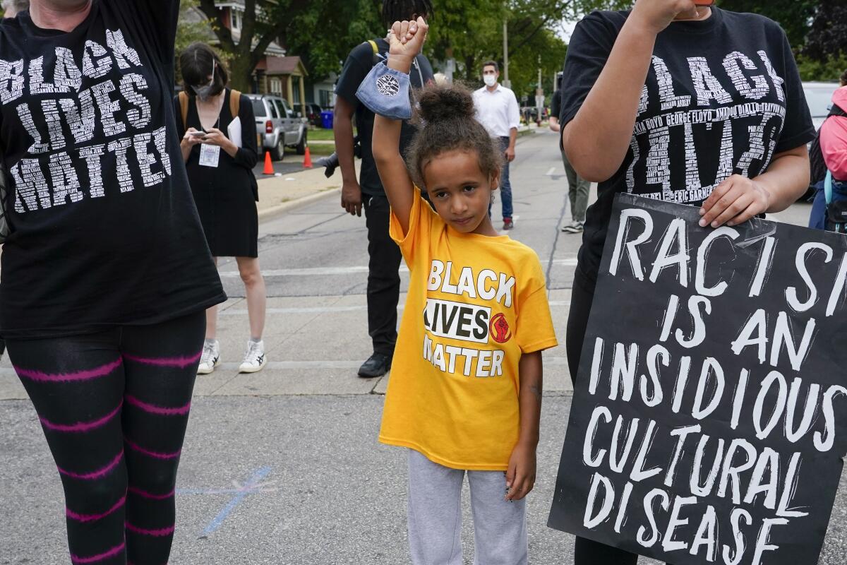 Six-year-old Deja holds her hand in the air during a Black Lives Matter protest on Tuesday in Kenosha, Wis.