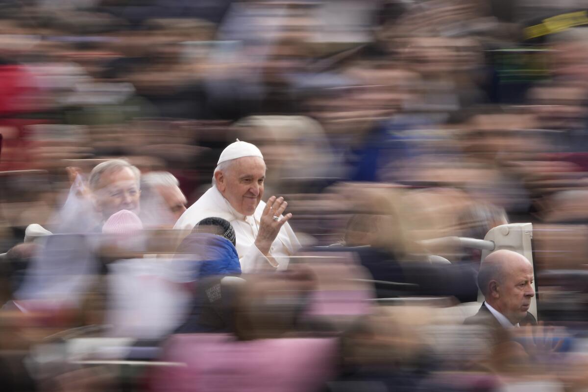 Pope Francis waves as he arrives for his weekly general audience in St. Peter's Square at the Vatican.