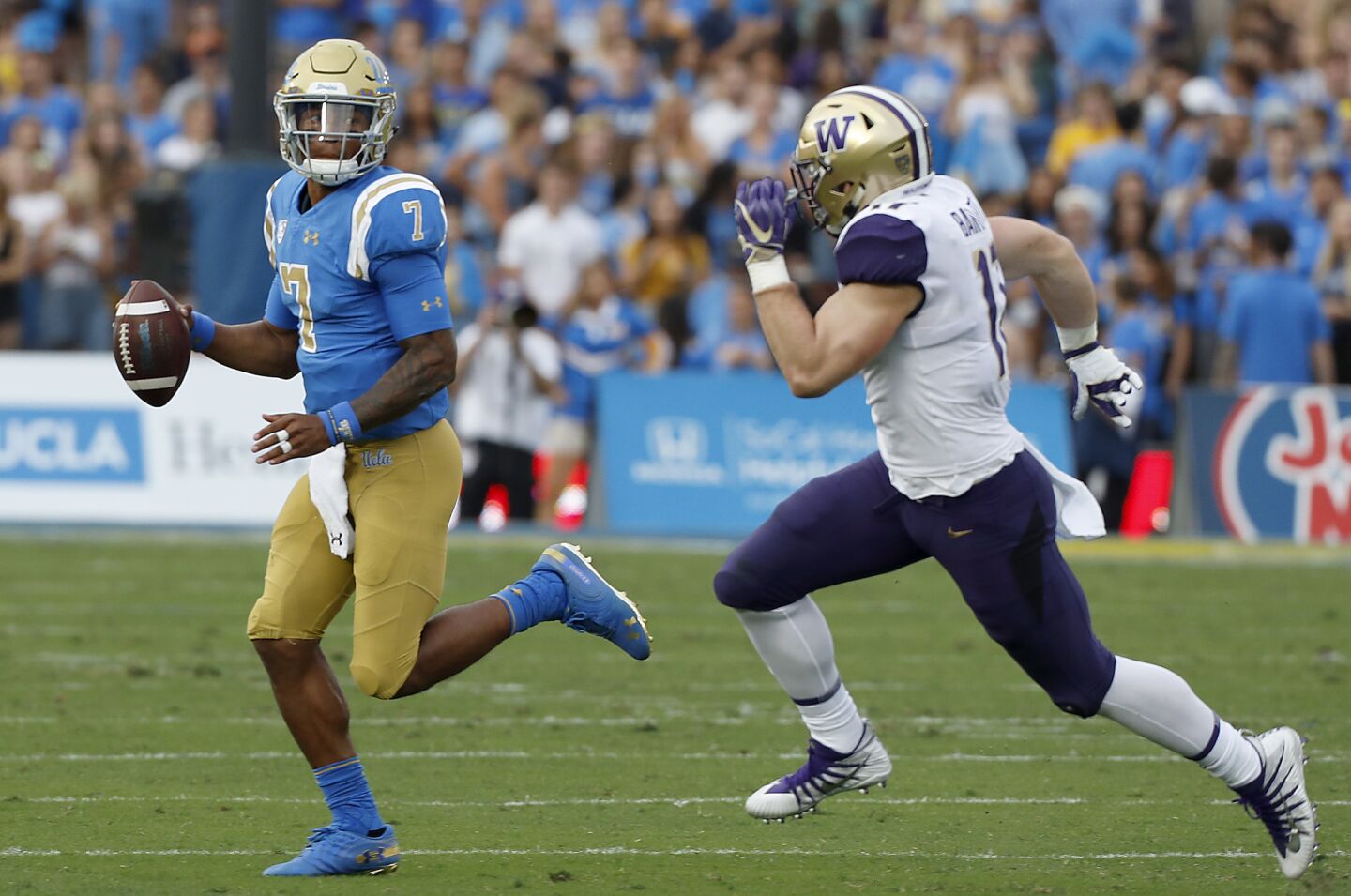 UCLA quarterback Dorian Thompson-Robinson is flushed out of the pocket by Washington linebacker Tevis Bartlett in the second quarter on Saturday at the Rose Bowl.