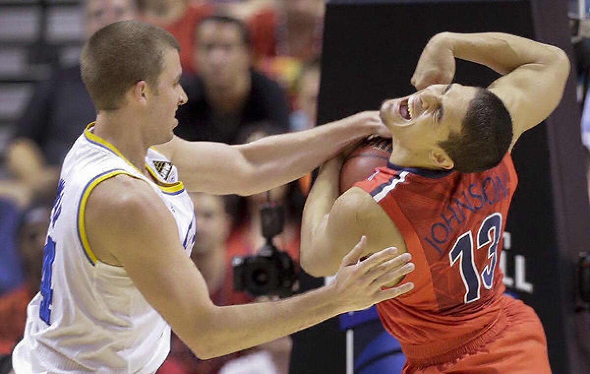 UCLA's Travis Wear, left, battles Arizona's Nick Johnson for the ball during last year's Pac-12 tournament semifinal contest between the two teams. The Bruins will look to hand the Wildcats their first loss of the season Thursday.