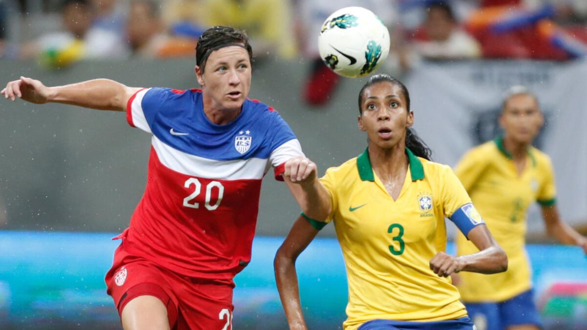 U.S. forward Abby Wambach, left, and Brazil defender Bruna Benites chase after the ball during the International Women's Football Tournament final in Brasilia, Brazil, on Dec. 11.
