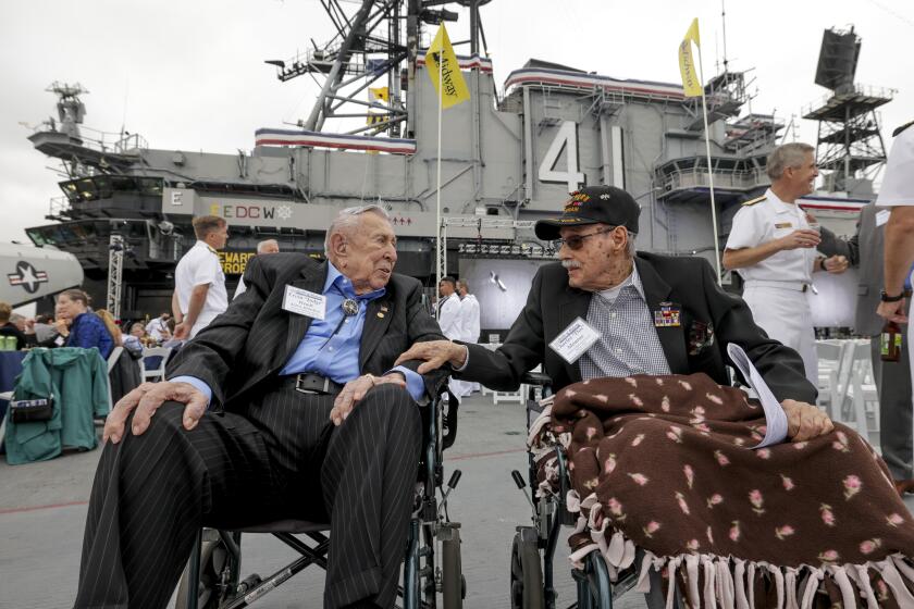 SAN DIEGO, CA - JUNE 4, 2022: Battle of Midway veterans Ervin "Judge" Wendt, 106, USN (Ret.) left, and Aviation Radioman First Class Charles Monroe, 98, who were both with USN Torpedo Squadron Eight during the Battle of Midway, talk while sitting next to each other before the start of the commemoration ceremony of the 80th anniversary of the Battle of Midway and the Centennial of U.S. Navy Aircraft Carriers at the USS Midway Museum in San Diego on Saturday, June 4, 2022. (Hayne Palmour IV / For The San Diego Union-Tribune)