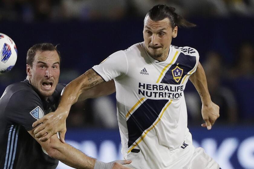 LA Galaxy forward Zlatan Ibrahimovic, right, is defended by Minnesota United defender Brent Kallman during the first half of an MLS soccer match Saturday, Aug. 11, 2018, in Carson, Calif. (AP Photo/Marcio Jose Sanchez)