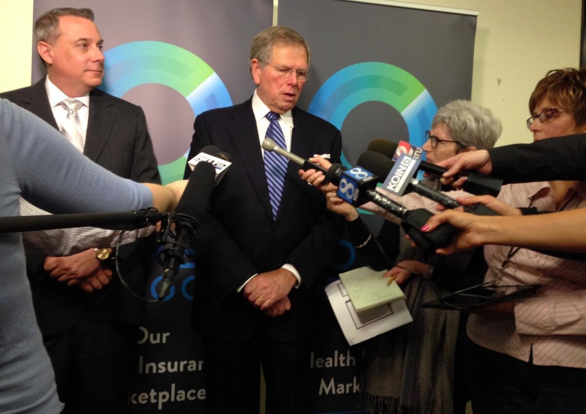 Cover Oregon official Clyde Hamstreet, center, and chief information officer Alex Pettit, left, speak with reporters in Durham, Ore., on Friday after Cover Oregon's board approved a recommendation to switch to the federal website.