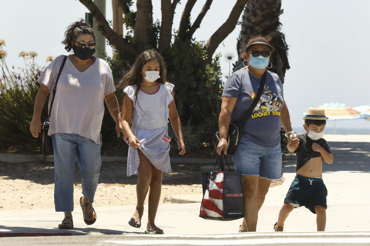 The Sanchez family, of Los Angeles, wear their masks while visiting Laguna Beach on Friday.
