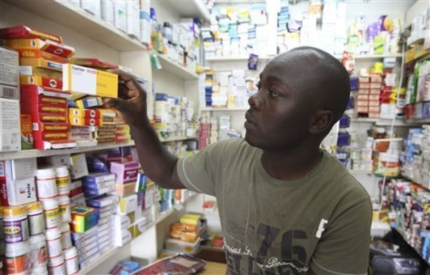 In this Monday, Aug. 30, 2010 photo, Ayo Bello displays a box of Coartem malaria medication, packaged for the commercial market, at a pharmacy in Lagos, Nigeria. Millions of free malaria drugs are sent to Africa every year by international donors. New research is now providing evidence for what health workers have long suspected: some of the donated medication, readily identifiable by its different packaging, is being stolen and resold on commercial markets. (AP Photo/Sunday Alamba)