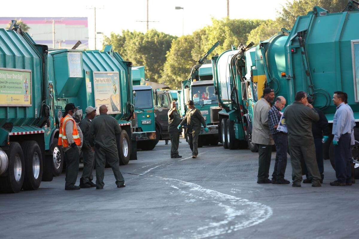 Los Angeles refuse collection workers prepare to leave the Mission Road sanitation yard after a short rally early Tuesday morning calling attention to a stalemate in contract talks with the city.