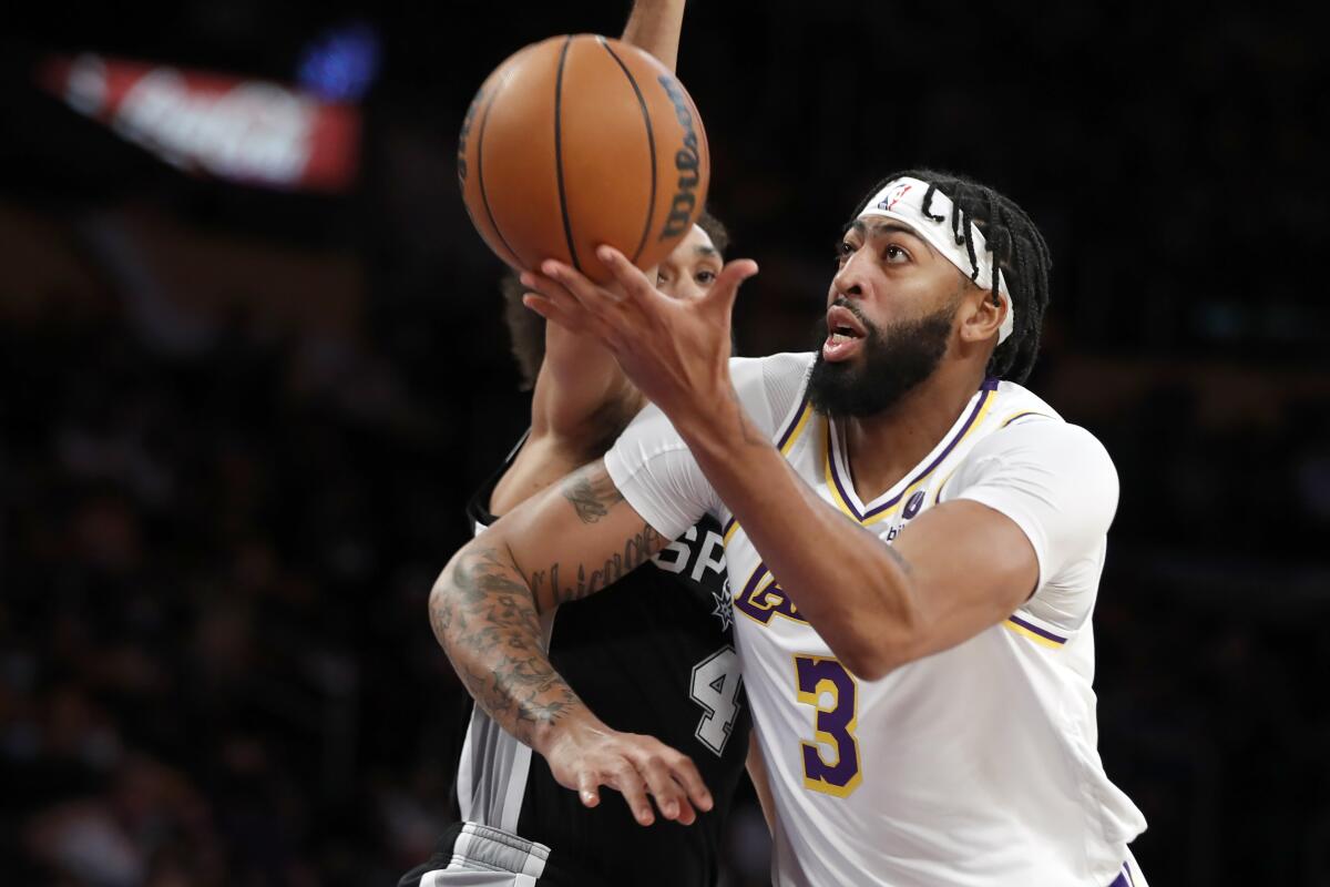 Lakers forward Anthony Davis drives past Spurs guard Derrick White.