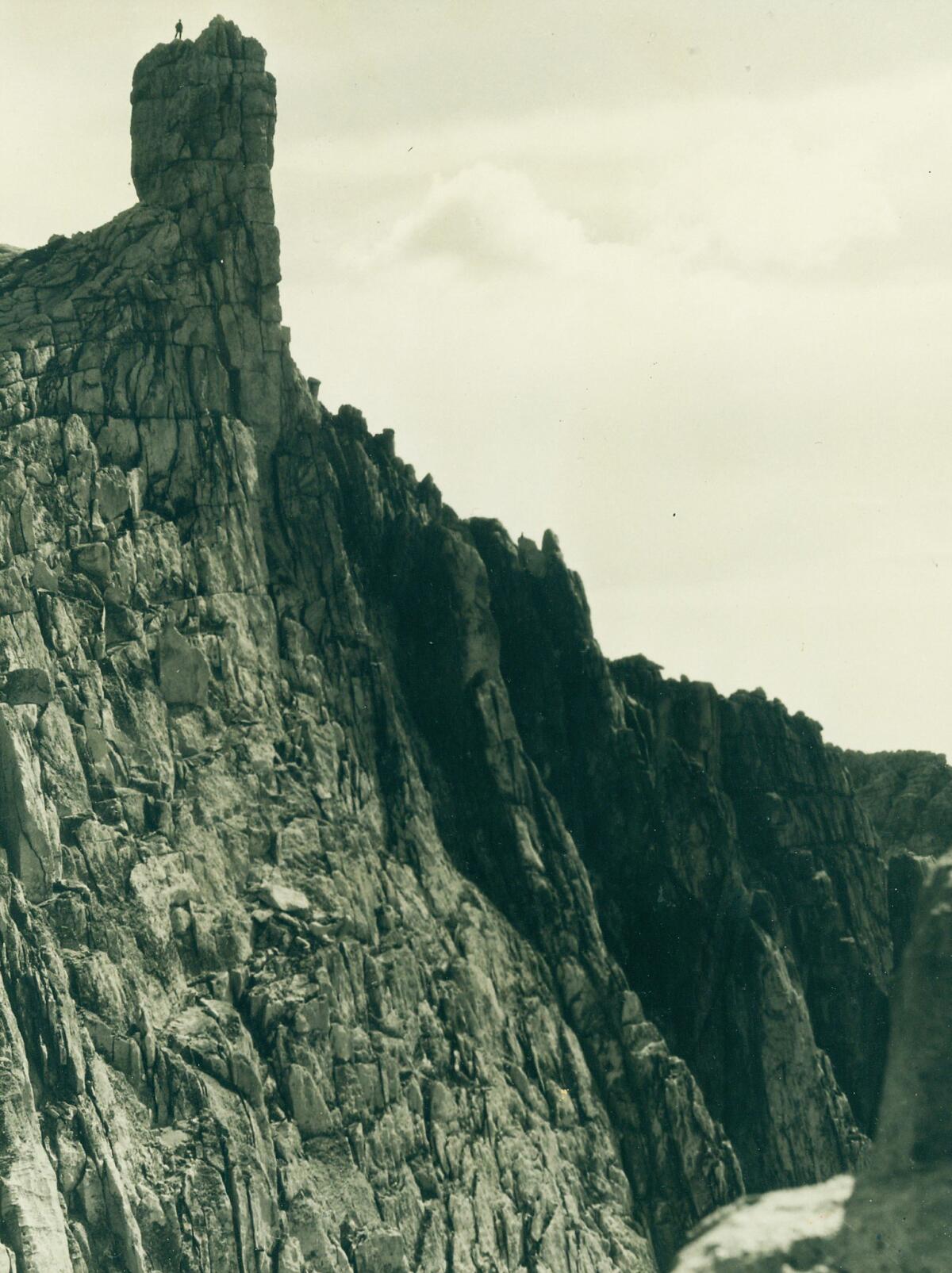 A figure stands on top of "an unusual rock formation near Vogelsang High Sierra Camp." Undated photo. (Los Angeles Times Library)