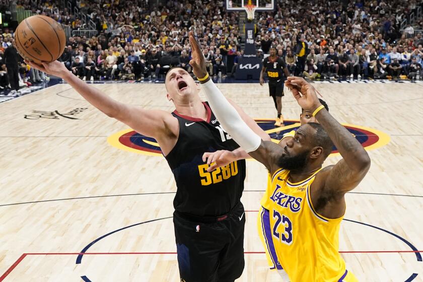 Denver Nuggets center Nikola Jokic (15) goes up for a shot against Los Angeles Lakers forward LeBron James