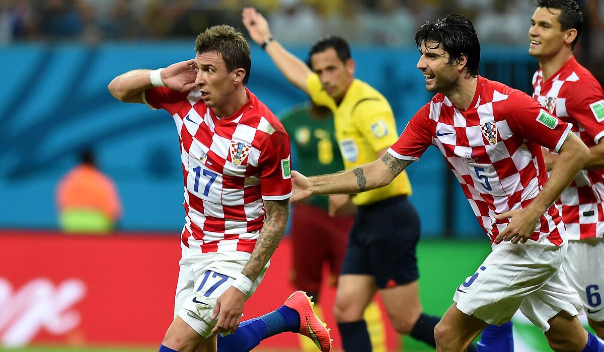 Croatia forward Mario Mandzukic (17) celebrates with teammates Vedran Corluka (5) and Dejan Lovren after scoring a goal against Cameroon in a World Cup Group A game on Wednesday in at Amazonia Arena in Manaus, Brazil.